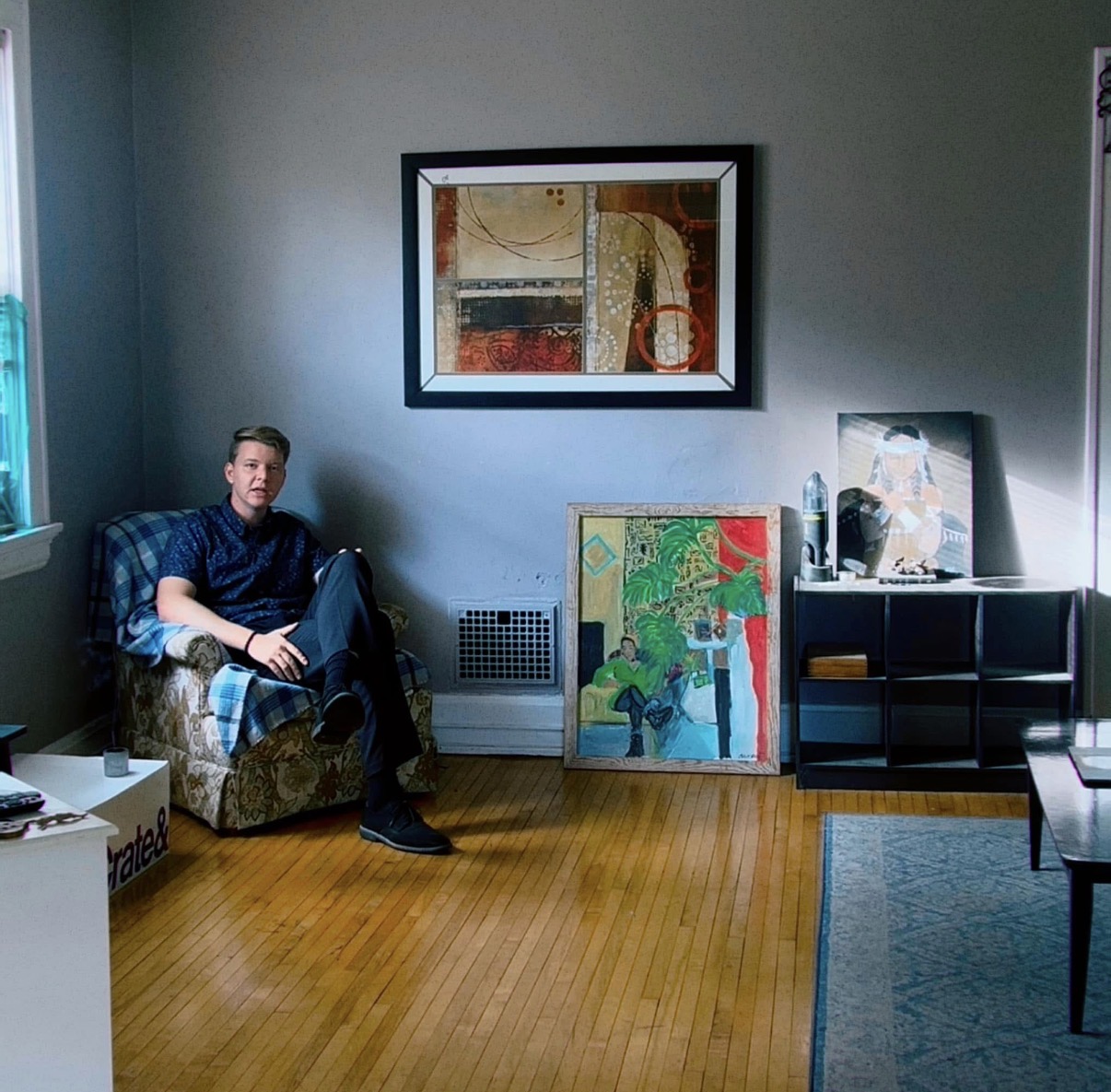 Interior with paintings, figure seated in an armchair
